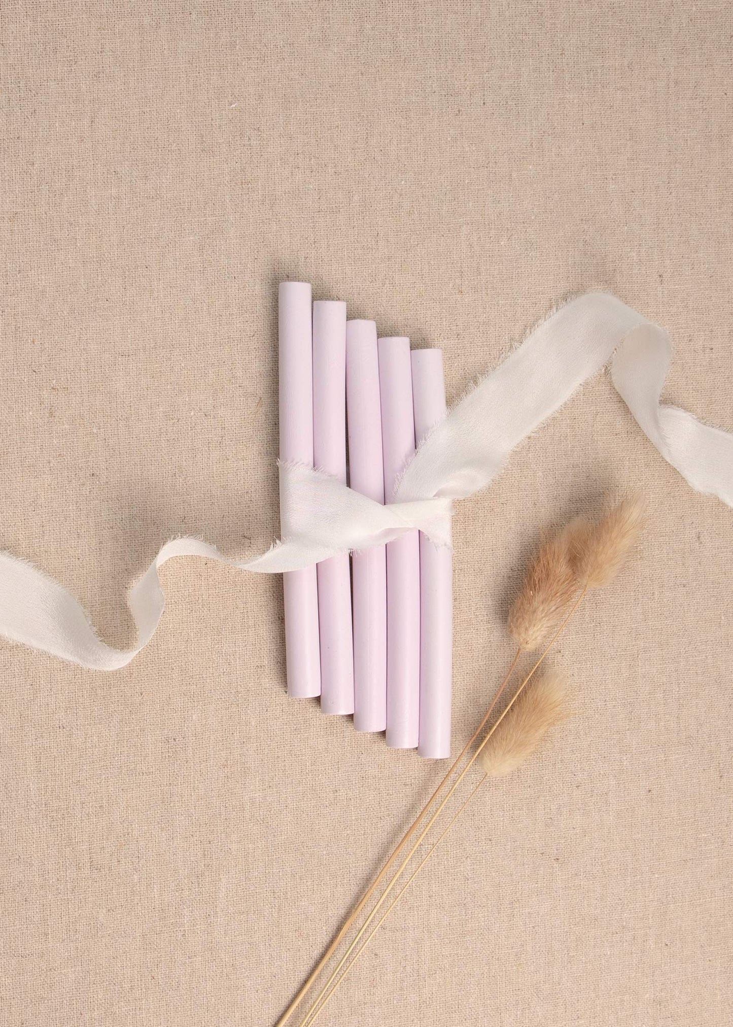 5 pack of Lilac wax seal sticks surrounded by white silk ribbon and dried flowers
