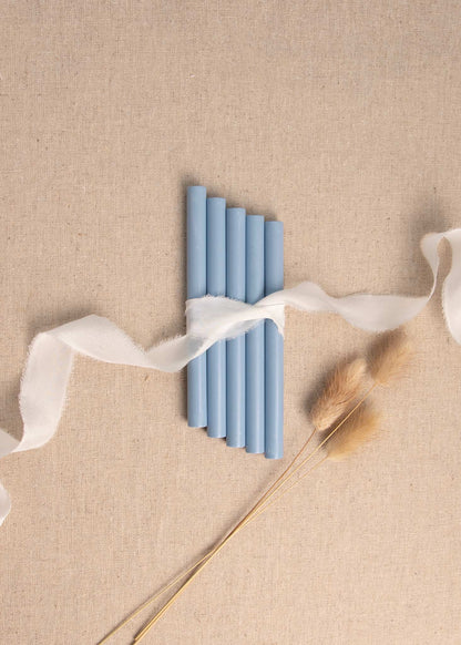 5 pack of Dusky Blue wax seal sticks surrounded by white silk ribbon and dried flowers