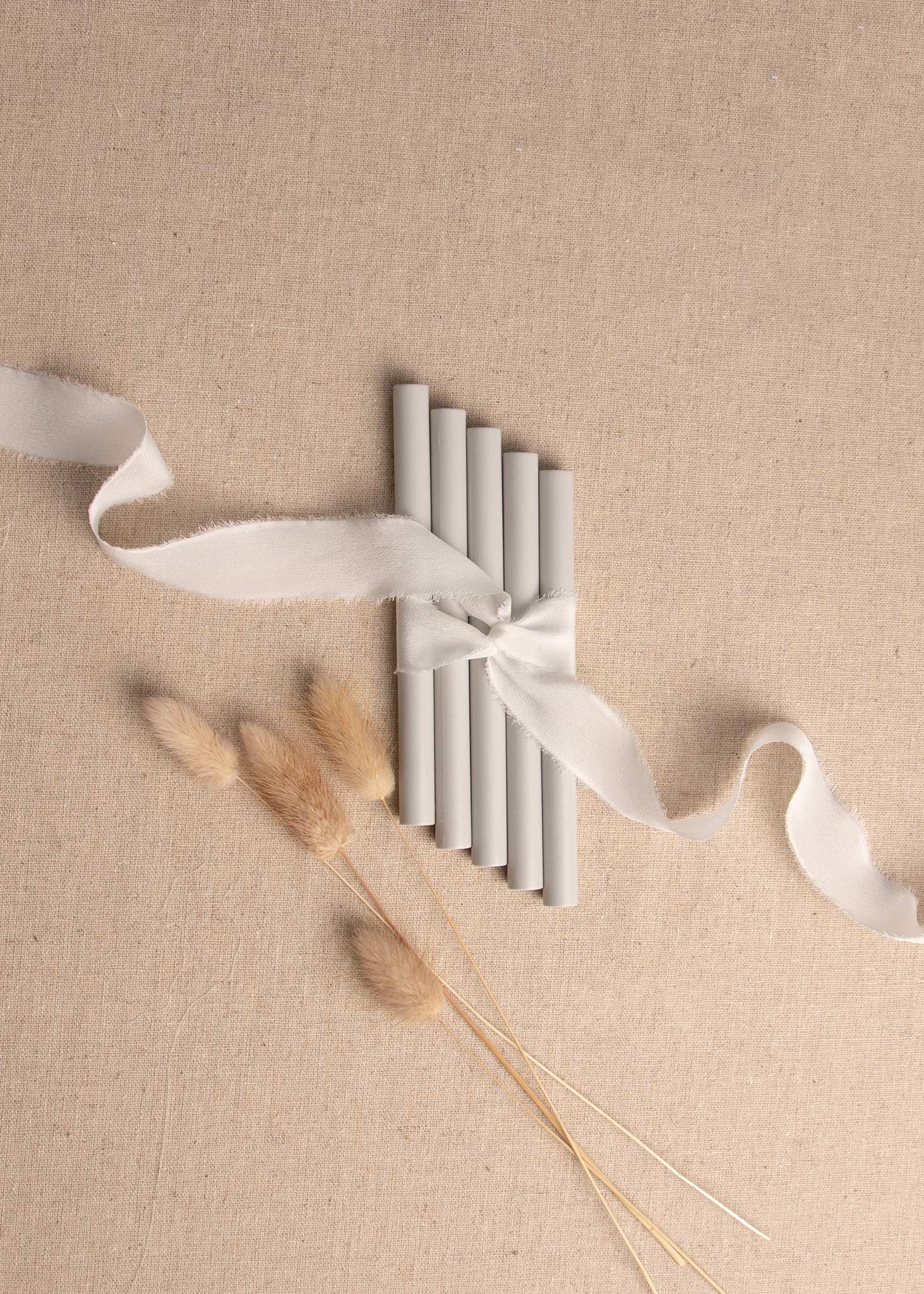 5 pack of Grey wax seal sticks surrounded by white silk ribbon and dried flowers