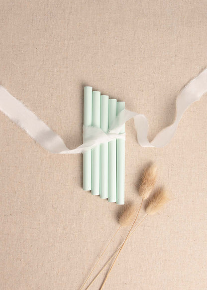 5 pack of Mint Green wax seal sticks surrounded by white silk ribbon and dried flowers