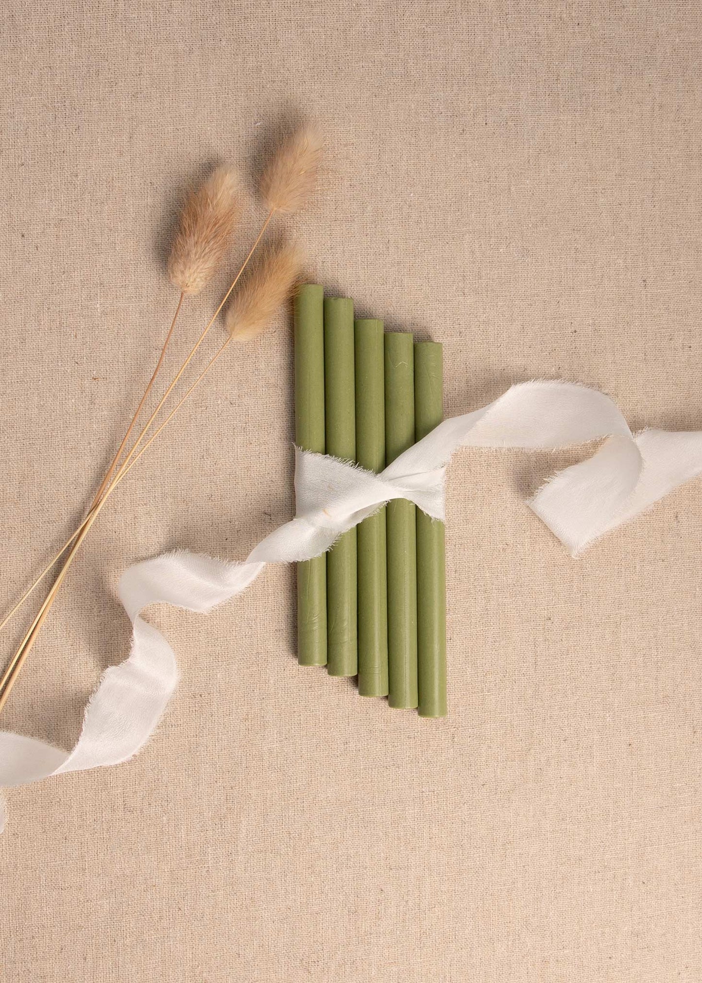 5 pack of Moss Green wax seal sticks surrounded by white silk ribbon and dried flowers