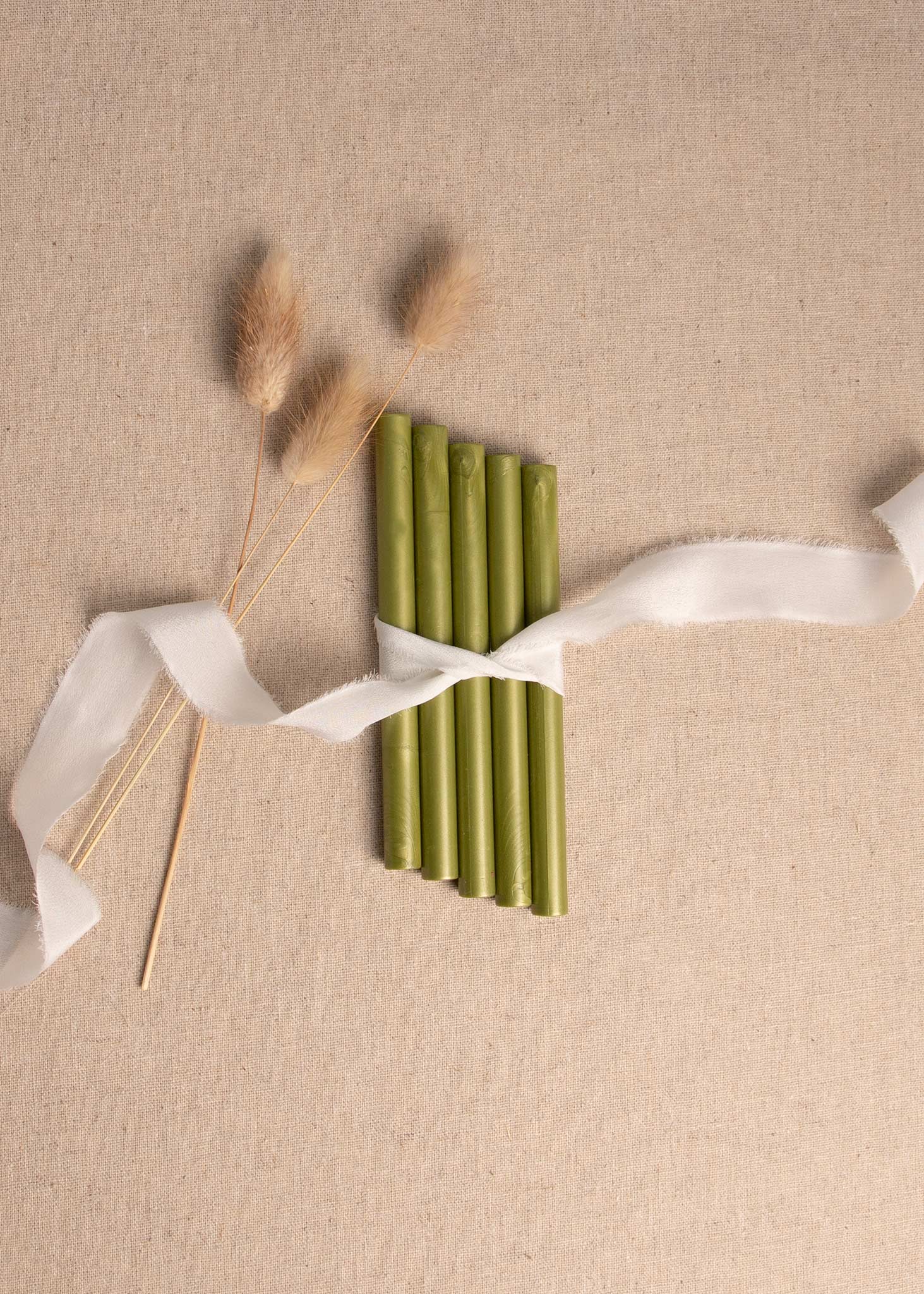 Olive Green wax seal sticks tied together with white ribbon and dried flowers 