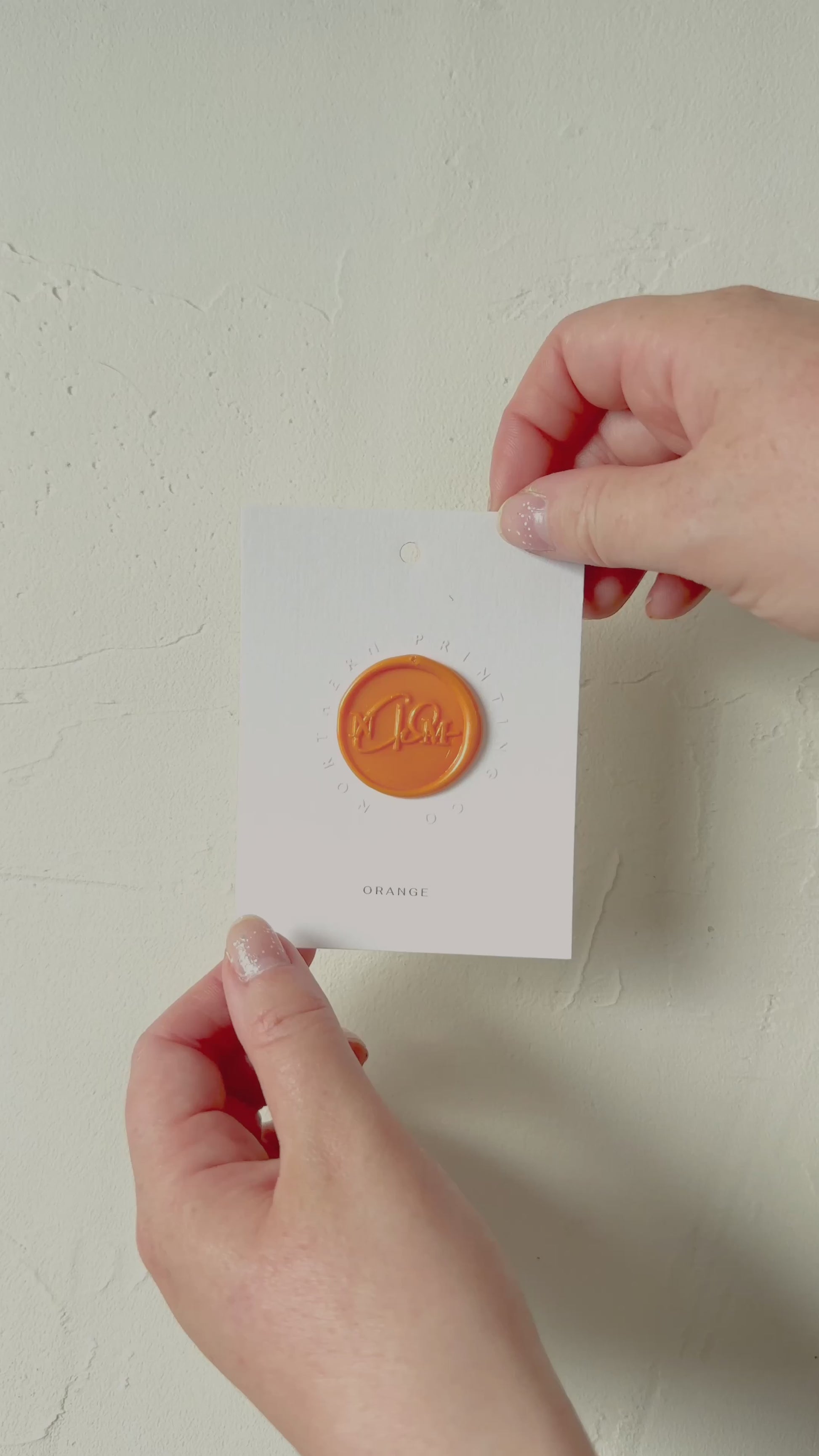 Video of Orange wax seal stamp sample on textured background