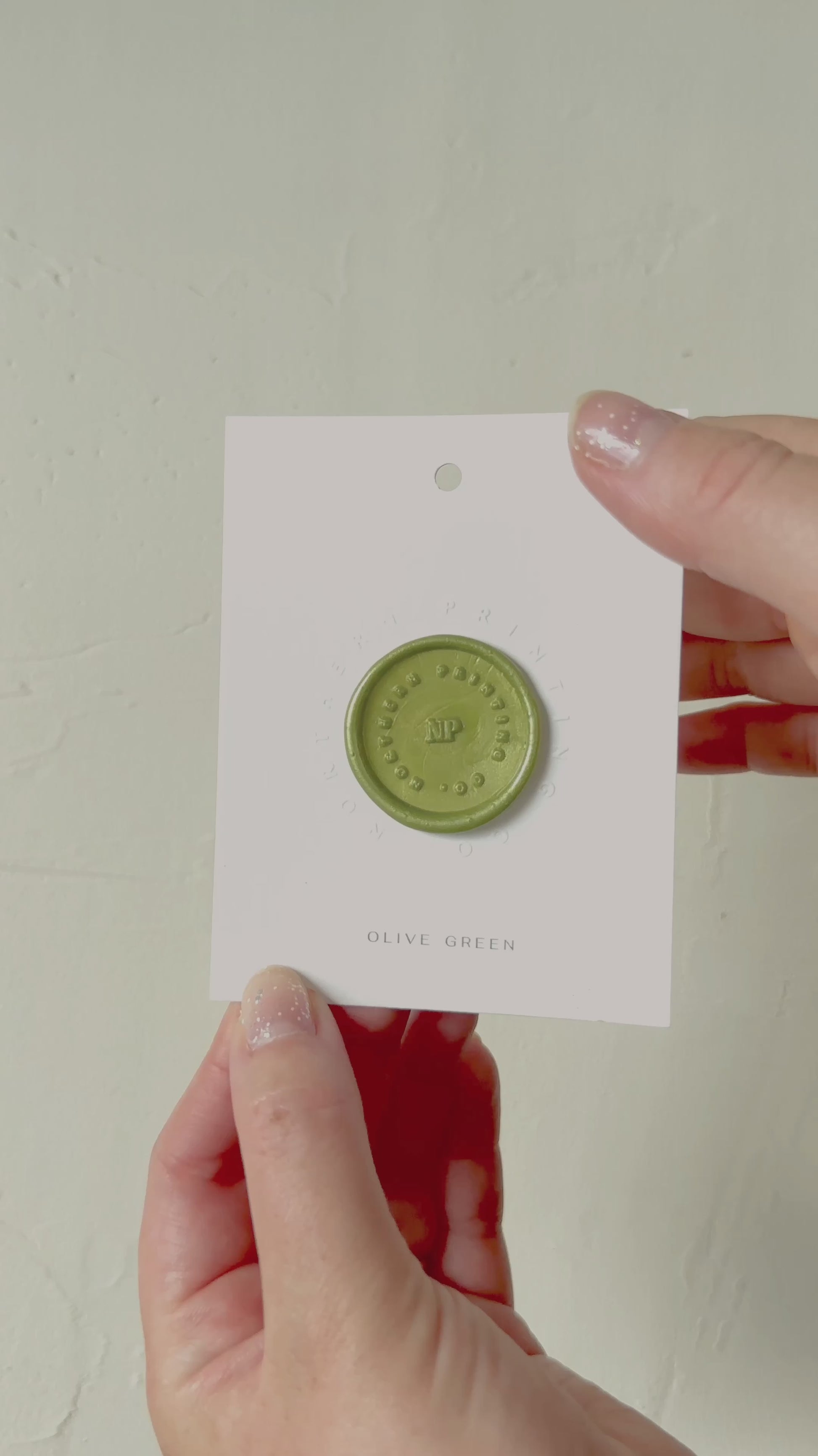 Video of Olive Green wax seal stamp sample on textured background