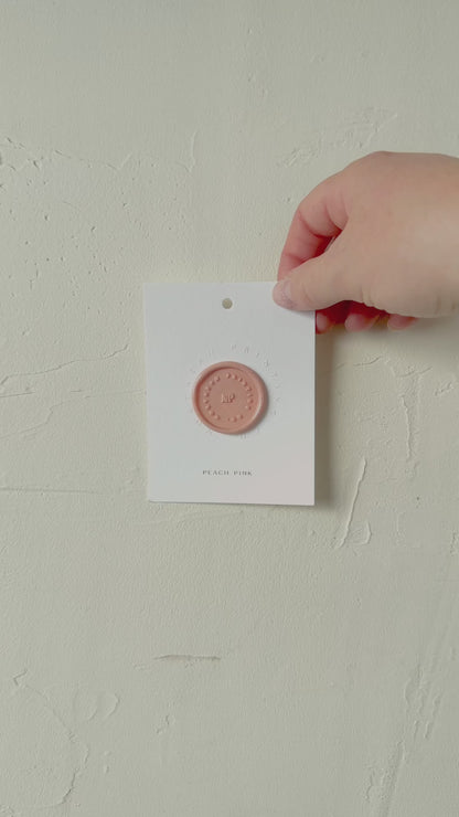 Video of Peach Pink wax seal stamp sample on textured background