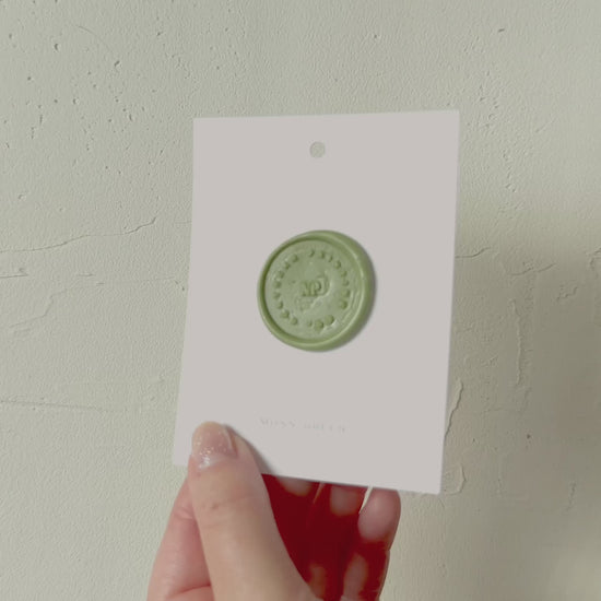 Video of Moss green wax seal stamp sample on textured background