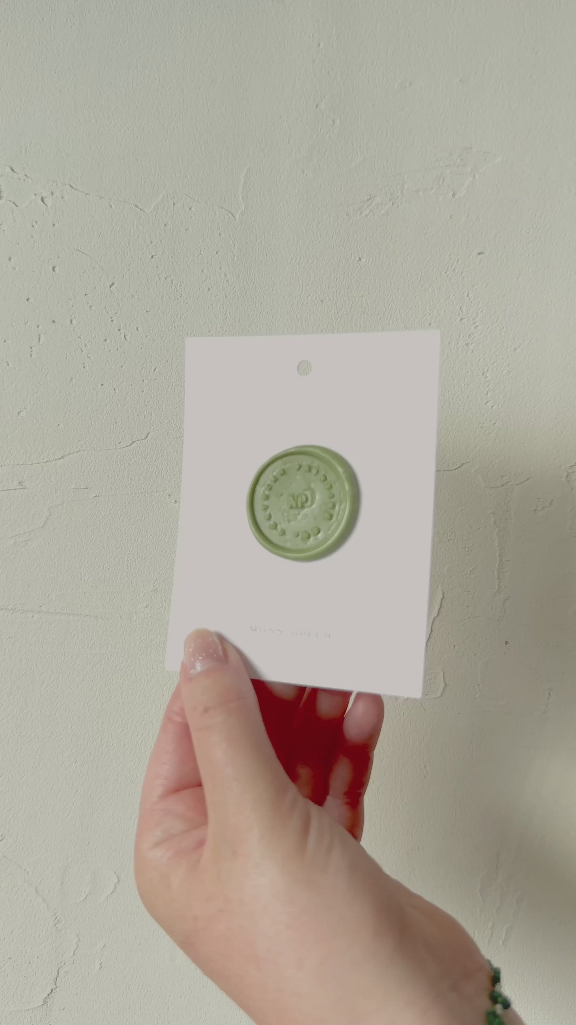Video of Moss green wax seal stamp sample on textured background