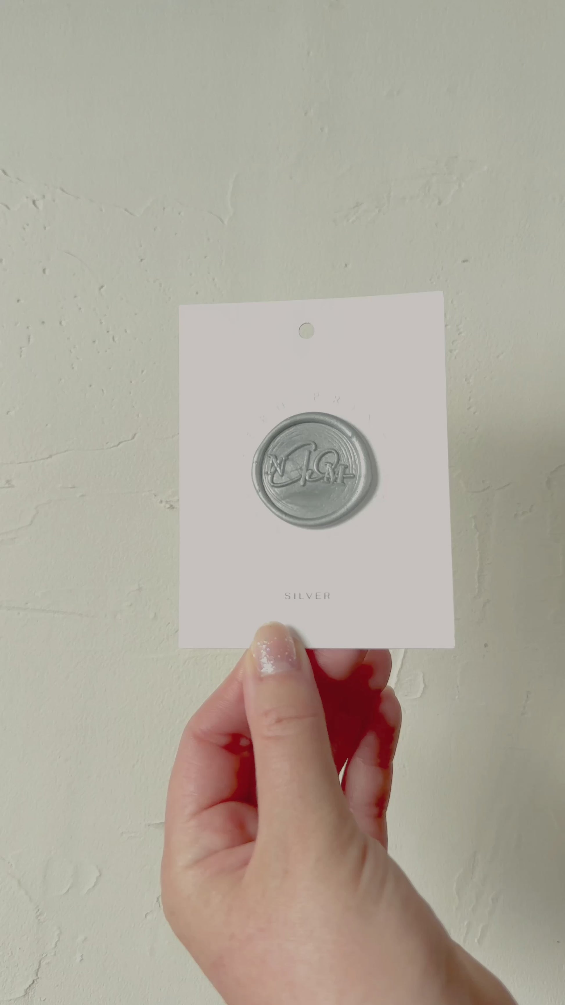 Video of Silver wax seal stamp sample on textured background