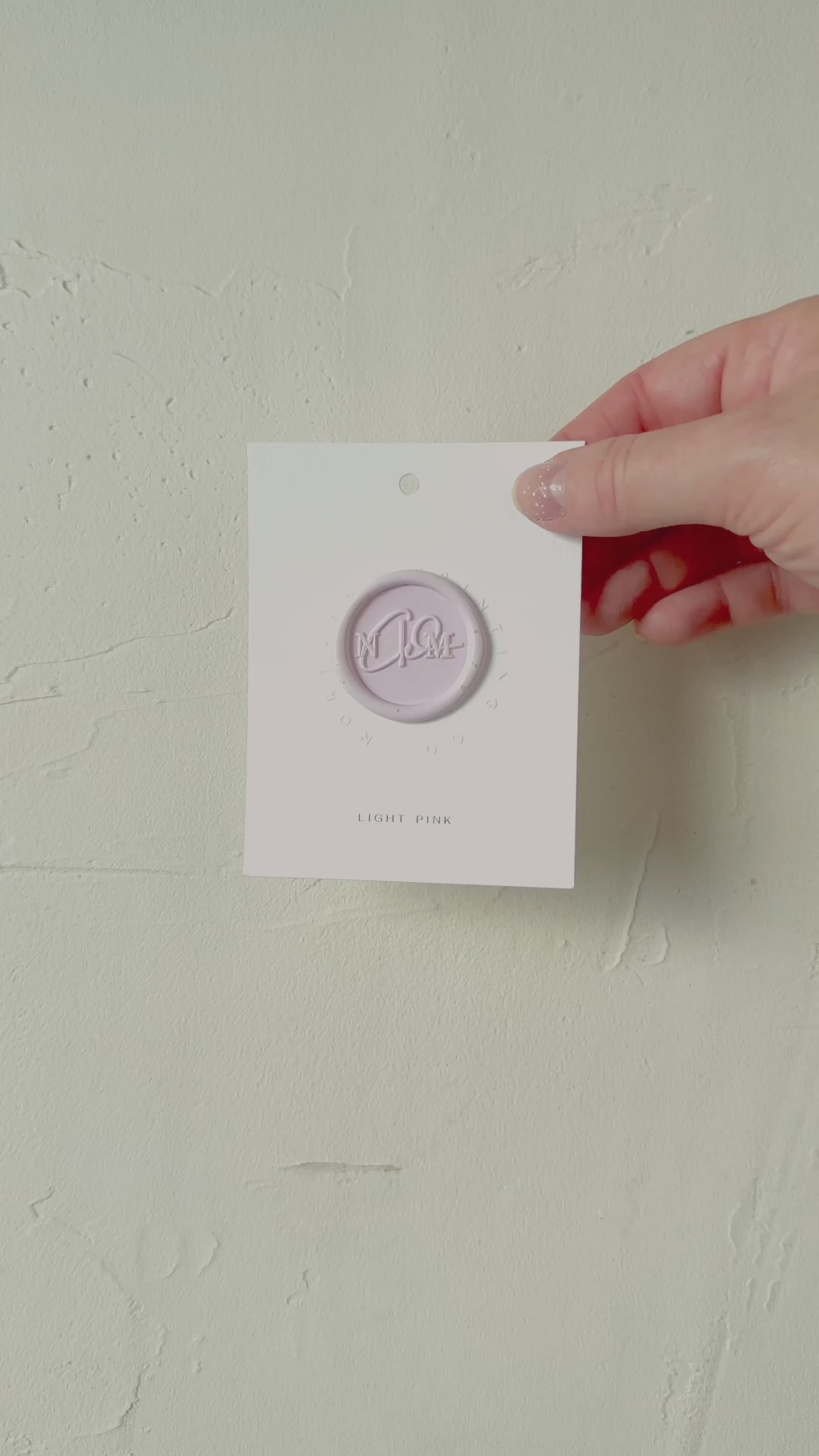 Video of Light Pink wax seal stamp sample on textured background