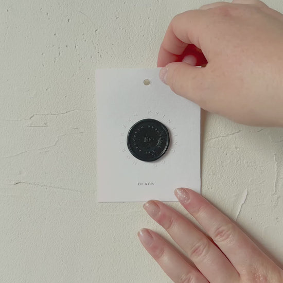 Video of Black wax seal stamp sample on textured background