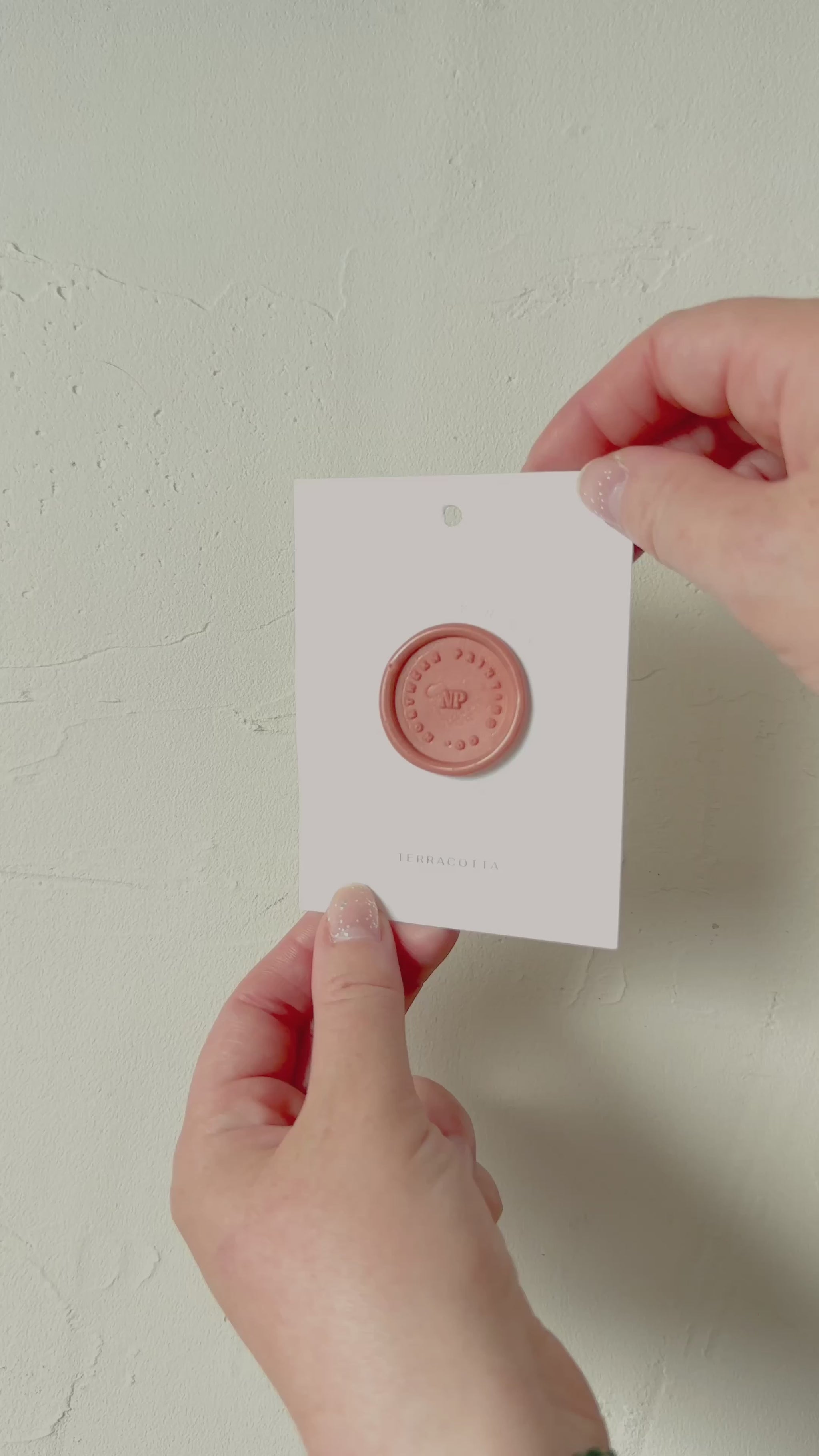 Video of terracotta wax seal stamp sample on textured background