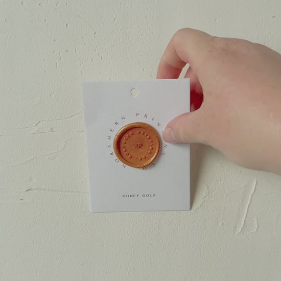 Video of Honey Gold wax seal stamp sample on textured background