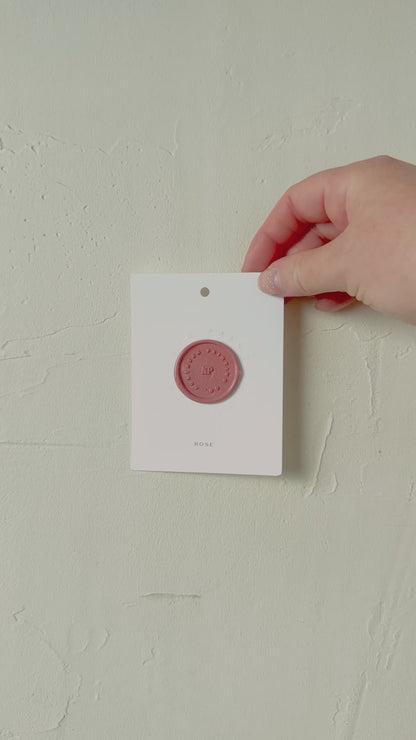 Video of Rose pink wax seal stamp sample on textured background
