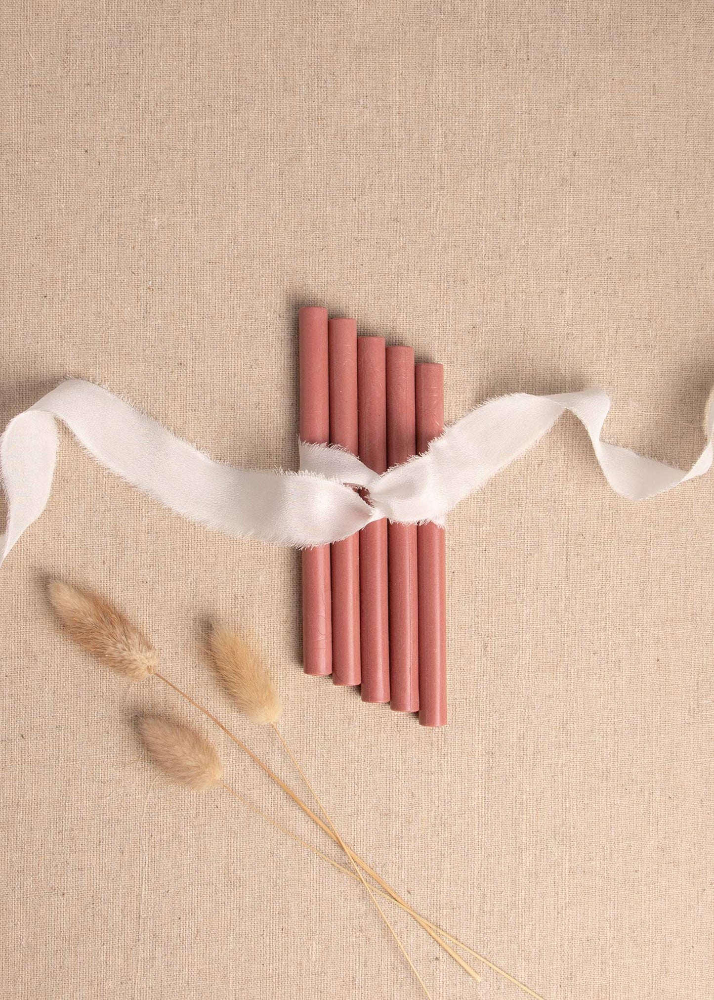 Rose wax seal sticks tied together with white ribbon and dried flowers 