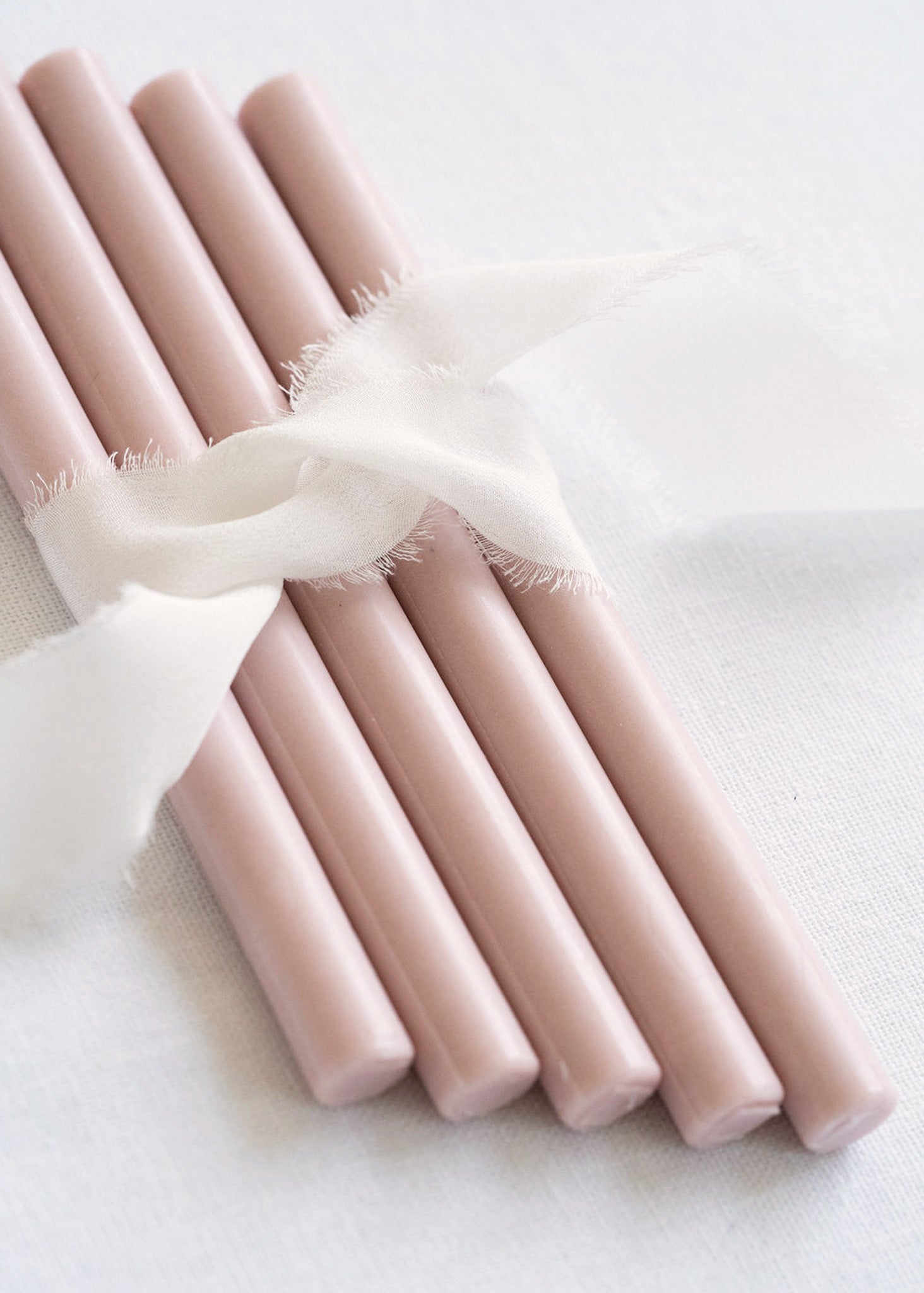 5 soft pink seal sticks tied together with white ribbon 