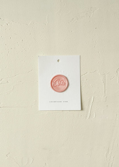 Elevated view of Champagne Pink wax seal stamp sample on textured background