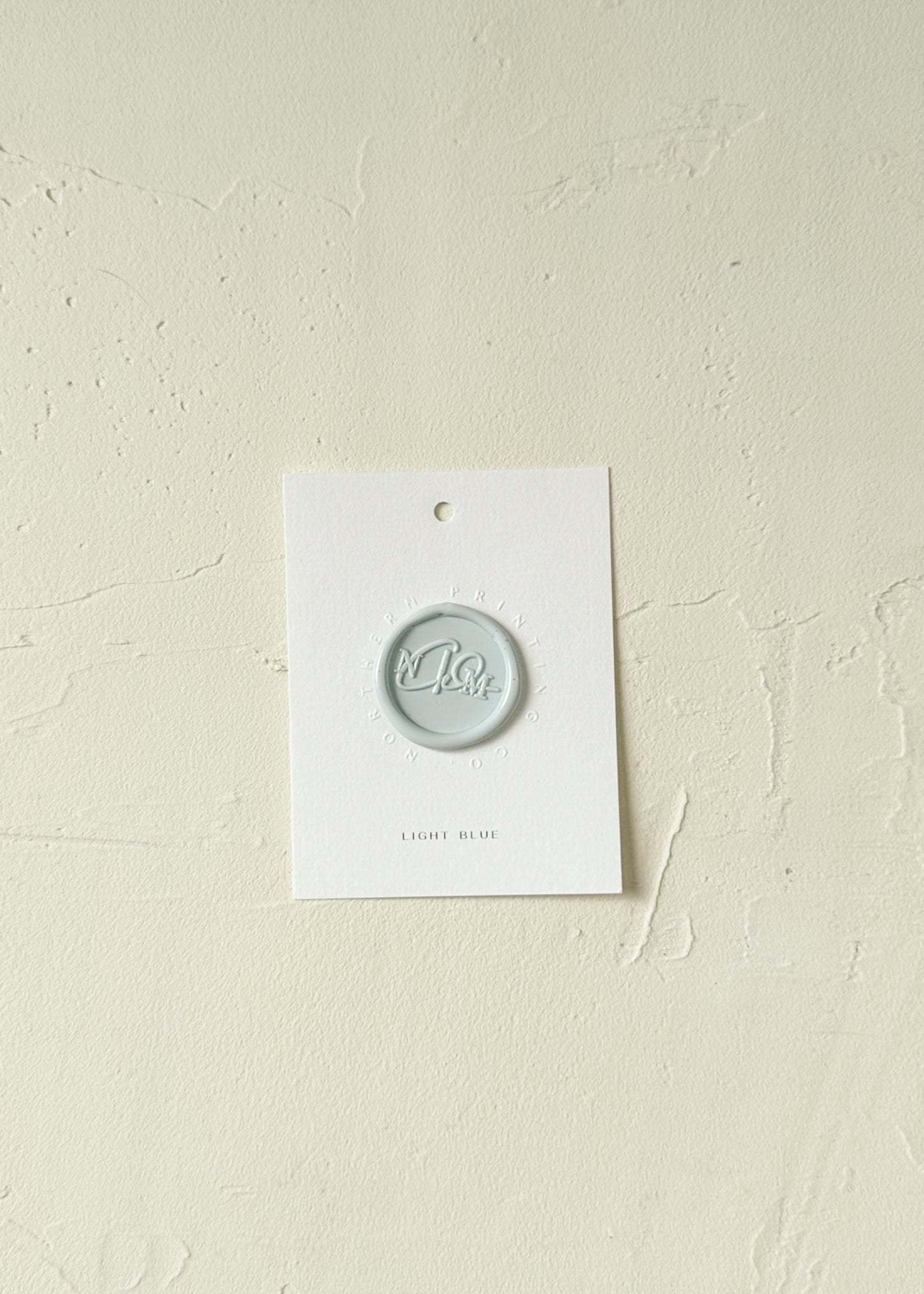 Elevated view of Light Blue wax seal stamp sample on textured background