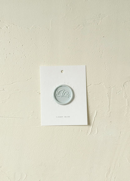 Elevated view of Light Blue wax seal stamp sample on textured background
